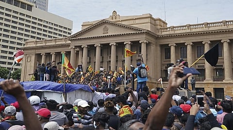 Protesters, many carrying Sri Lankan flags, gather outside the presidents office in Colombo