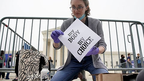 Nat McGartland, 27, of College Park, Maryland, makes signs on a letterpress during a protest outside the US SC after leak of a draft majority opinion written by Justice Samuel preparing for a majority of the court to overturn the landmark Roe v. Wade abortion-rights decision later this year, in Washington