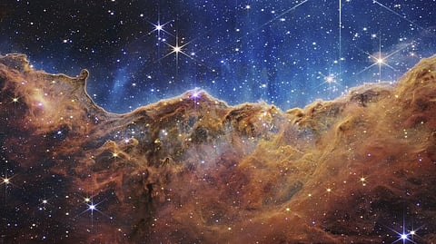 This image released by NASA shows the edge of a nearby, young, star-forming region NGC 3324 in the Carina Nebula. The image reveals previously obscured areas of star birth, according to NASA.