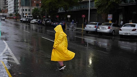 A woman walks under the rain in Caracas