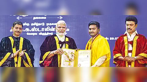 PM Modi awards a degree to a student during the 42nd Convocation of Anna University. CM Stalin and Governor Ravi are also seen