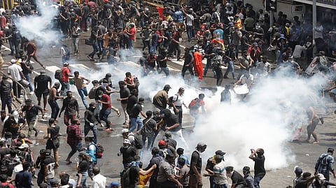 Demonstrators run from tear gas used by police during a protest demanding the resignation of President Gotabaya Rajapaksa