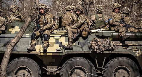 Ukrainian soldiers sit on an armored military vehicle in the city of Severodonetsk