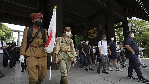 Visitors in old Japanese Imperial army uniforms enter Yasukuni Shrine, which honors Japan's war dead