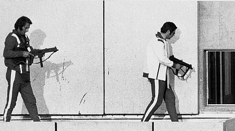 Two West German policemen wearing sweat suits and armed with machine guns get into position on the roof of the Munich Olympic Village building, on Sept. 5, 1972, as armed Arab commandos hold Israeli Olympic team members hostage.