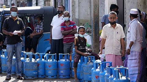 Sri Lankans wait in a queue for a refill of their cooking gas cylinders in Colombo