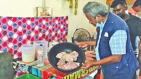 A FSSAI official examining the food items at an eatery in Coimbatore on Sunday during a raid
