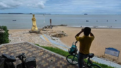 A man looks through a pair of binoculars in Xiamen, across Taiwan's Kinmen Islands on August 3, 2022