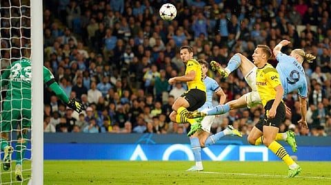 Erling Haaland, right, scores his side's 2nd goal during the group G Champions League soccer match between Manchester City and Borussia Dortmund at the Etihad stadium in Manchester, England.