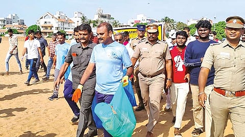 Union Minister L Murugan picking up waste from Besant Nagar beach as part of the Coastal Cleanup Day initiatives.