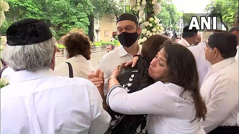 Several prominent figures are present at the crematorium for his funeral.