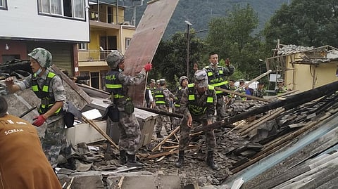 Soldiers clear debris to search for survivors at an earthquake hit Moxi Town