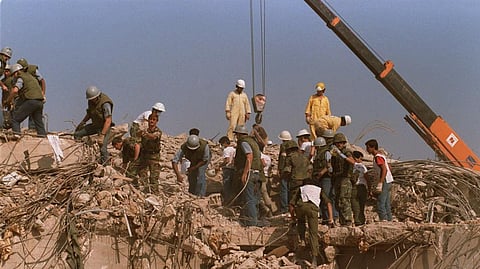 Rescue workers sift through the rubble of the U.S. Marine base