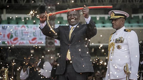 Kenya's new president William Ruto holds up a ceremonial sword