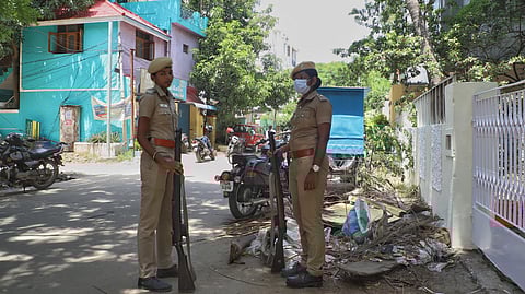 Police personnel stand guard at a place where DVAC raids are happening