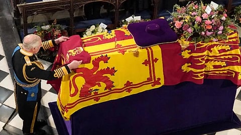 King Charles III places the Queen's Company Camp Colour of the Grenadier Guards on the coffin at the Committal Service for Queen Elizabeth II, held at St George's Chapel in Windsor Castle.