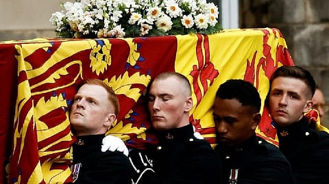 Pallbearers carry the coffin of Queen Elizabeth II, draped with the Royal Standard of Scotland, as it arrives at Holyroodhouse, where it will lie in rest for a day, in Edinburgh