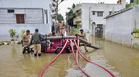 Fire brigade personnel pump water from a flooded street after heavy rain, at Horamavu area in Bengaluru.