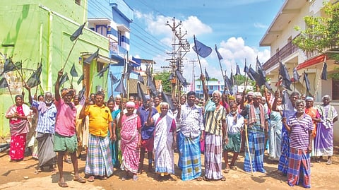 Alavanthankulam villagers showing black flags against taking over of grazing lands for solar project on Sunday.