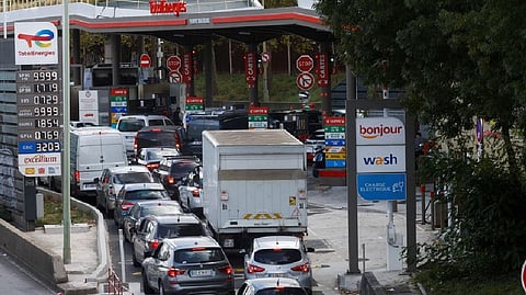 Cars queue to fill their fuel tanks at a Total petrol station in Paris