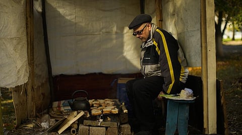 Anton Sevrukov, 47, toasts bread over fire in a makeshift stove in Kivsharivka, Ukraine