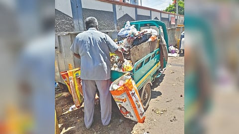 A sanitary worker physically segregating dry and wet waste collected from homes in Chennai.