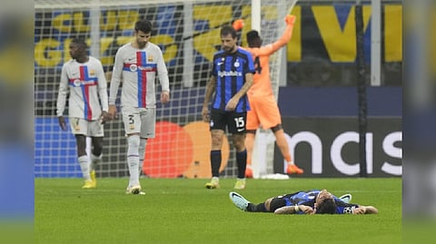 Inter Milan's Lautaro Martinez lies on the ground celebrating at the end of the Champions League group C soccer match between Inter Milan and Barcelona at the San Siro stadium in Milan, Italy