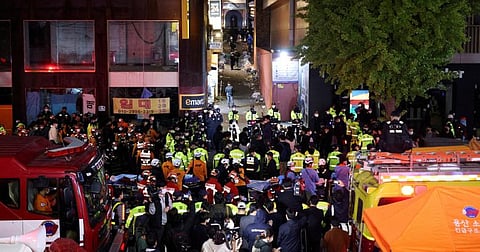 Rescue team and firefighters work at the scene where dozens of people were injured in a stampede during a Halloween festival in Seoul