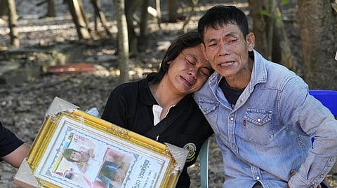 Tukta Wongsila grieves with her father Saart as holds her daughter Siriprapa ?Plai Fon? Prasertsuk's picture, one of the many victims of a mass killing attack in the rural town of Uthai Sawan, north eastern Thailand.
