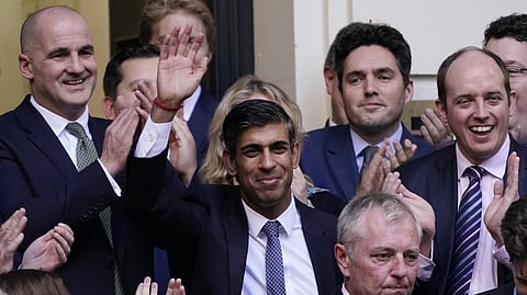 Rishi Sunak, centre, waves after winning the Conservative Party leadership contest at the Conservative party Headquarters in London.