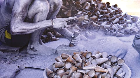 A worker filling up chemicals while making crackers in Sivakasi