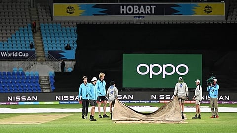 Pitch being covered by groundsmen