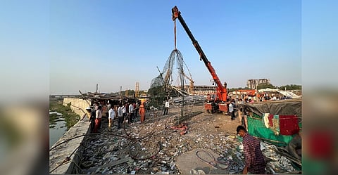 People remove debris after a suspension bridge collapsed in Morbi town