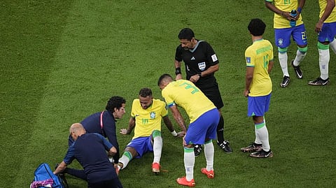 Brazil's Neymar, lies on the pitch as he receives first aid during the World Cup group G soccer match between Brazil and Serbia, at the the Lusail Stadium in Lusail, Qatar.