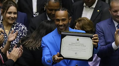British Mercedes Formula One driver Lewis Hamilton shows his title of Honorary Citizen of Brazil during a ceremony at the Chamber of Deputies in Brasilia, Brazil.