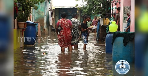 people wading through water-logged street