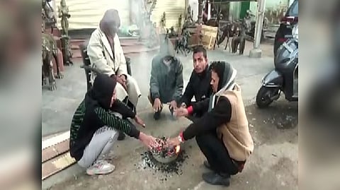 People gather around a bonfire as temperature dips at Mount Abu