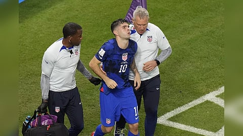 U.S. forward Christian Pulisic is assisted by trainers