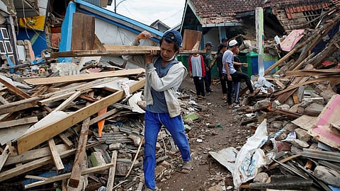 A local salvages goods from the rubble of a damaged house after Monday's earthquake hit Cianjur