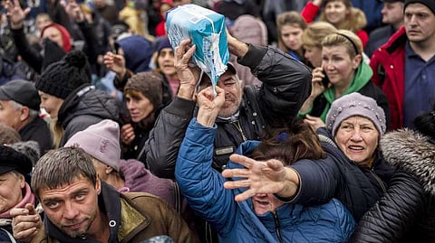 Residents gathering at an aid distribution point receive supplies in downtown Kherson, southern Ukraine.