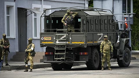 Russian soldiers guard an area as a group of foreign journalists visit in Kherson