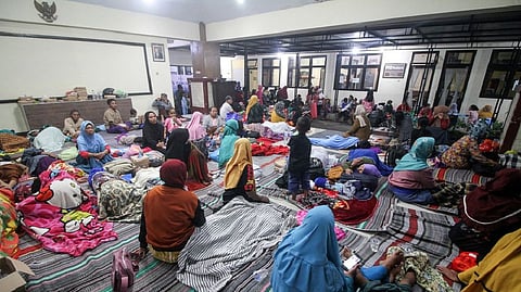Villagers rest as they shelter at a district office after being evacuated following the eruption of Mount Semeru volcano in Lumajang