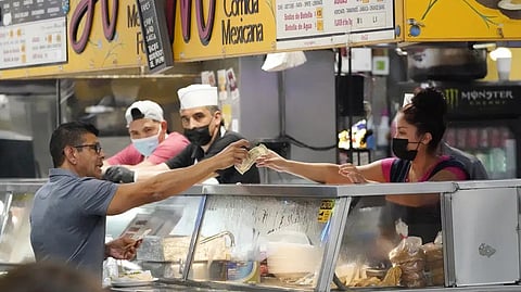 Money is exchanged at a food stand inside Grand Central Market on Wednesday in Los Angeles.