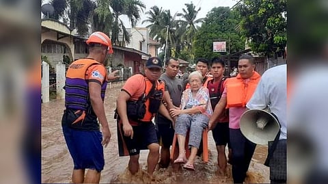 Rescue workers helps a resident affected by floods, in Plaridel, Misamis Occidental Province, Philippines, December 26, 2022. Philippine Coast Guard.