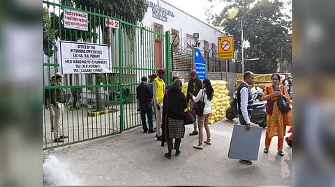 Polling officials come out of a polling booth