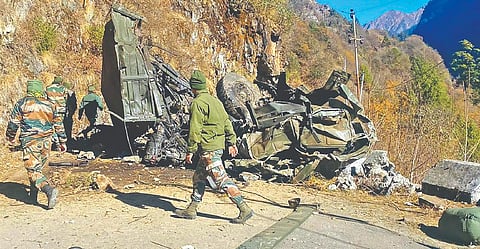 Rescue personnel near the mangled remains of the Army truck