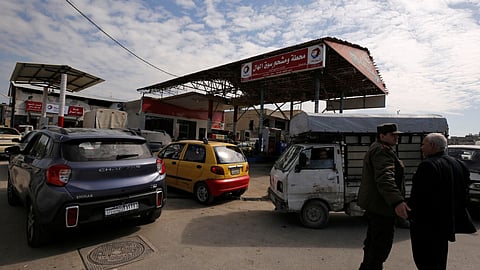 Cars stand in line at a gasoline station as they wait to fuel up in Aleppo