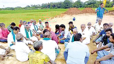 Farmers on hunger strike at the venue; (below) soil intended for road project being spread over paddy fields