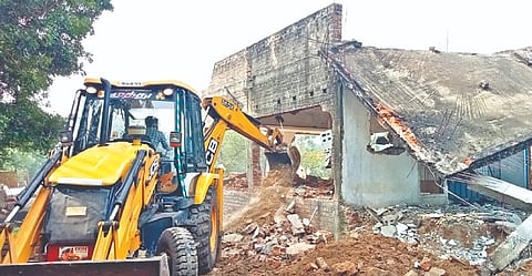 Revenue officials removing a house from encroached land in Chengalpattu on Thursday