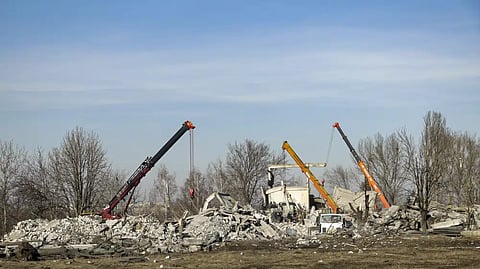 Workers clean rubbles after Ukrainian rocket strike in Makiivka, in Russian-controlled Donetsk region, eastern Ukraine, Tuesday, Jan. 3, 2023.